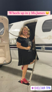 Woman entering a private plane with a glass of champagne
